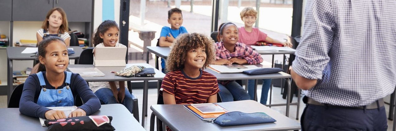 Bildung im Regionalverband Schüler mit Tablets und Schulmäppchen und Büchern hören lächelnd ihrem Lehrer zu